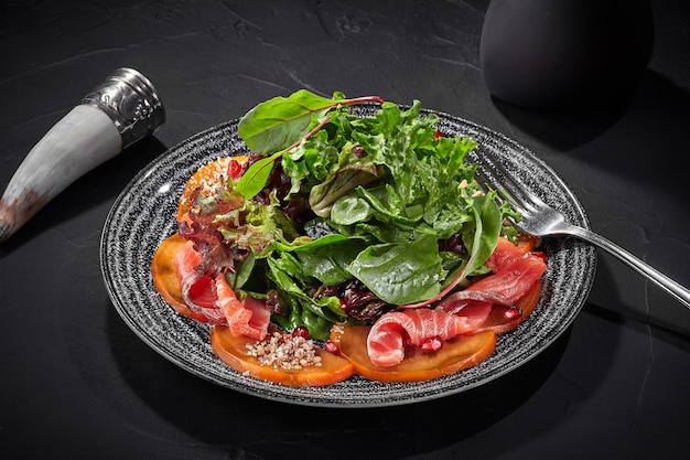 Insalata di cachi verdi e salmone salato con melograno e noci