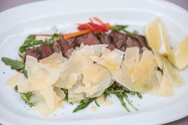 Insalata di carne alla griglia, servita con parmigiano e rucola