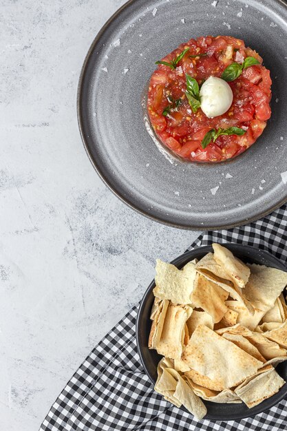 Insalata di carpaccio di pomodoro fatto in casa con mozzarella, olio d'oliva e basilico con pane arabo