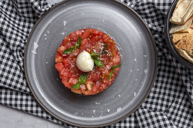 Insalata di carpaccio di pomodoro fatto in casa con mozzarella, olio d'oliva e basilico con pane arabo