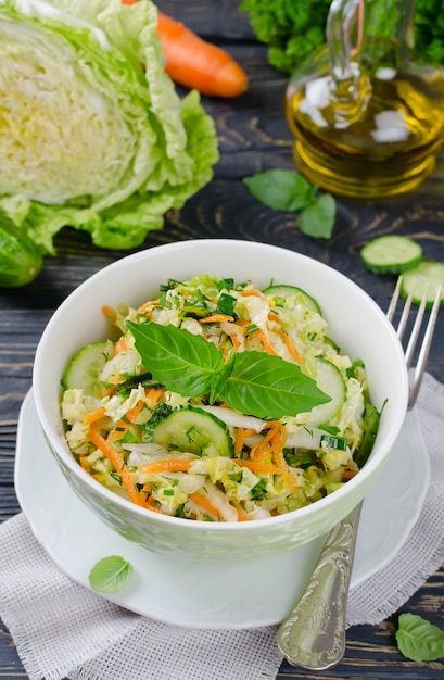 Insalata di cavolo cappuccio con cetrioli e carote. Insalata e verdure sulla tavola di legno