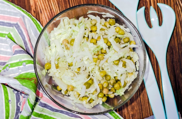 Insalata di cavolo cappuccio fresco e piselli in scatola in un'insalatiera