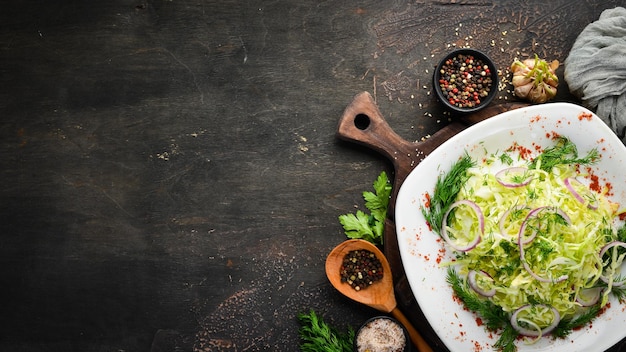 Insalata di cavolo cappuccio fresco e prezzemolo in un piatto Sullo sfondo vecchio spazio di copia gratuito