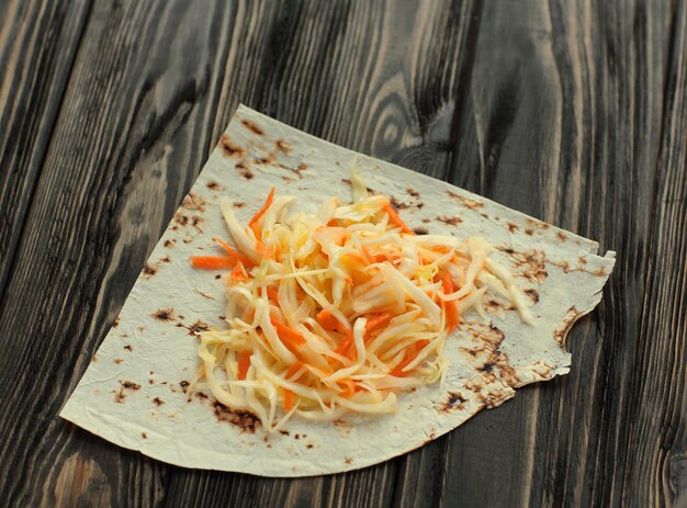 Insalata di cavolo cappuccio su pane pita su fondo di legno