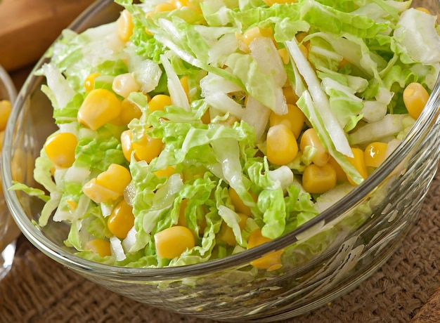 Insalata di cavolo cinese con mais dolce in una ciotola di vetro