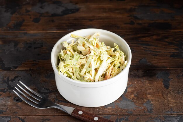 Insalata di cavolo Insalata di cavolo cappuccio con condimento su fondo di legno