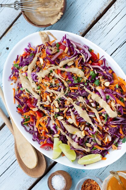 Insalata di cavolo rosso vegetariano vista dall'alto e quinoa in un piatto su fondo di legno blu