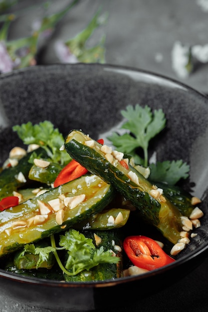 Insalata di cetrioli rotti con semi di sesamo, zucchero, pepe rosso e nero, olio d'oliva