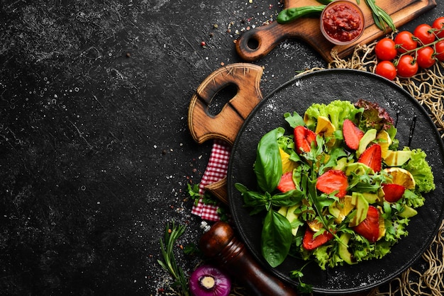 Insalata di cibo sano di rucola avocado fragola e arancia Vista dall'alto Spazio libero per il testo