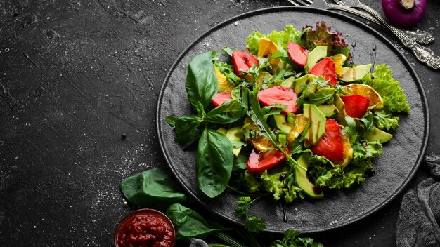 Insalata di cibo sano di rucola avocado fragola e arancia Vista dall'alto Spazio libero per il testo