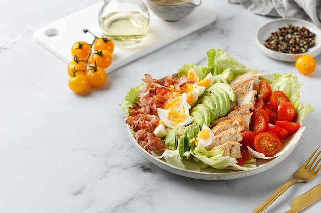 Insalata di Cobb con pancetta uova di pollo pomodoro avocado isolate su sfondo bianco Insalata americana