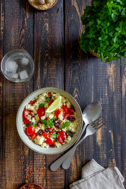 Insalata di cous cous con pomodori, peperoni, zucchine e mirtilli rossi. Cibo vegetariano. Dieta. Mangiare sano.