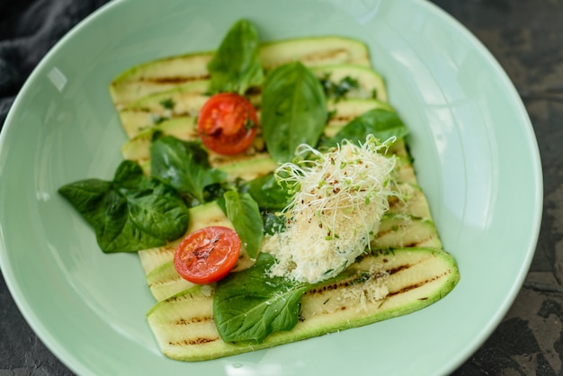 Insalata di fette di zucchine con pomodorini, crema di formaggio e micro verdi. Cibo vegetariano