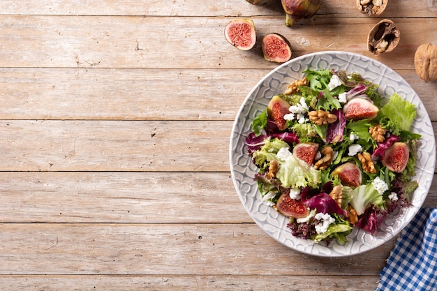 Insalata di fichi con formaggio e noci su tavola in legno rustico