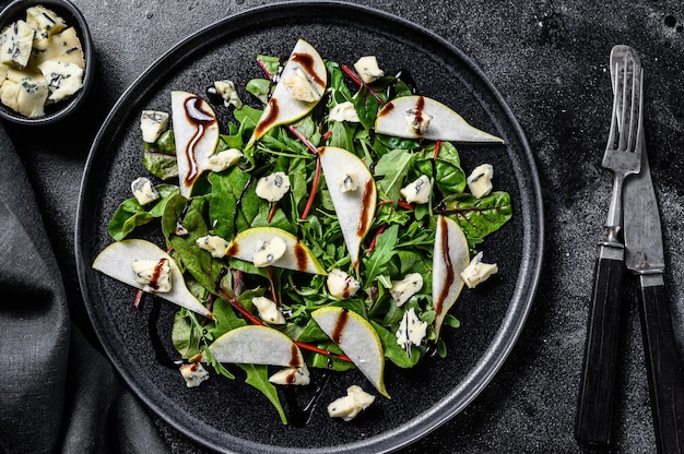 Insalata di formaggio blu con, pere, noci, bietole e rucola. Sfondo nero. Vista dall'alto.