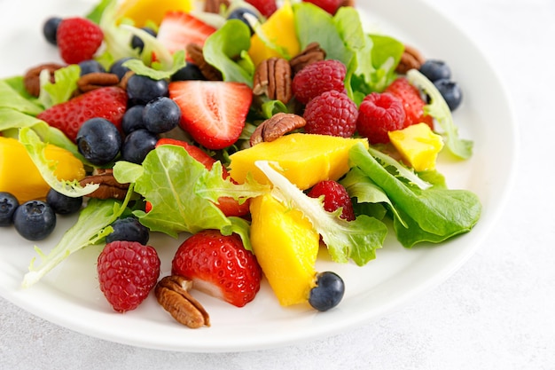 Insalata di frutta e bacche con fragola mirtillo lampone mango e noci pecan Dieta alimentare sana