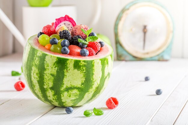 Insalata di frutti tropicali in anguria con frutti di bosco