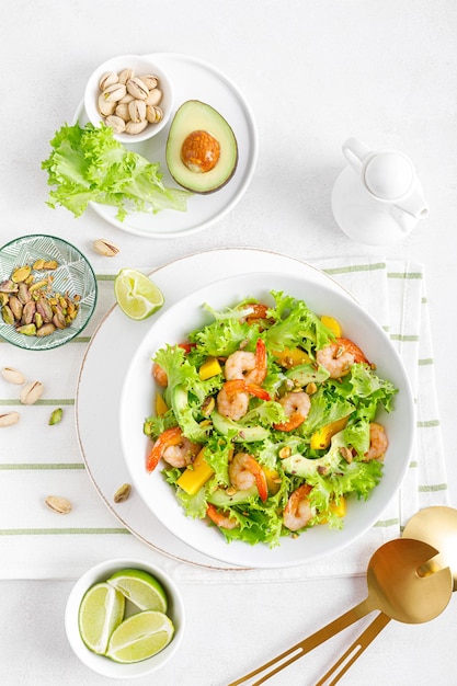 Insalata di gamberi alla griglia con lattuga avocado mango e pistacchi conditi con lime Cibo sano Dieta chetogenica Vista dall'alto