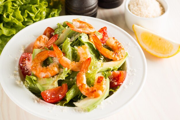 Insalata di gamberi Caesar fresca con deliziosi gamberi, rucola, spinaci, cavoli, rucola, uova, parmigiano e pomodorini Concetto di cibo sano e dieta.