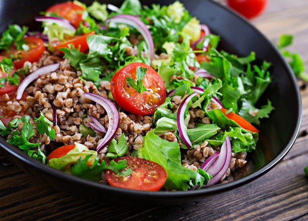 Insalata di grano saraceno con pomodorini, cipolla rossa ed erbe fresche. Cibo vegano. Menu dietetico.