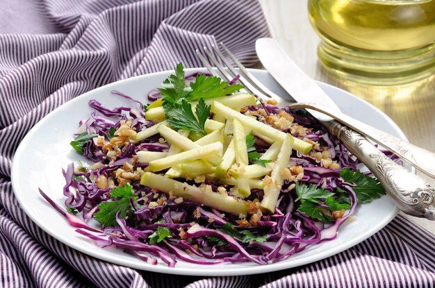 Insalata di insalata di cavolo rossa con fettine di mela e noci tritate