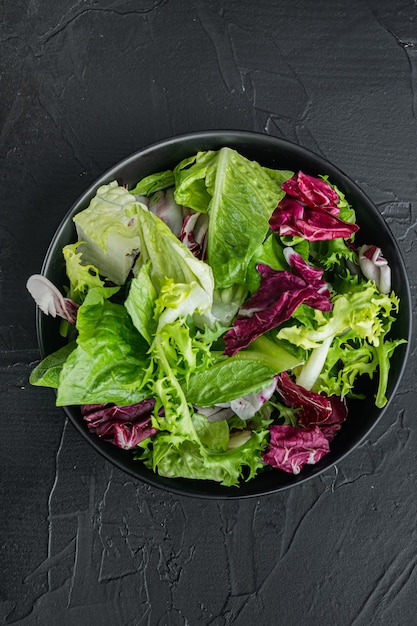 Insalata di lattuga fregio, romana e radicchio, su sfondo nero, vista dall'alto piatta