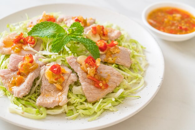 Insalata di maiale piccante o maiale bollito con aglio e salsa al peperoncino