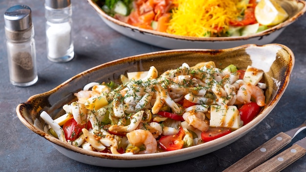 Insalata di mare su un piatto. Insalata sana e dietetica con calamari, gamberi e verdure.