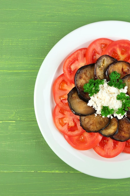 Insalata di melanzane con pomodori e feta su fondo di legno