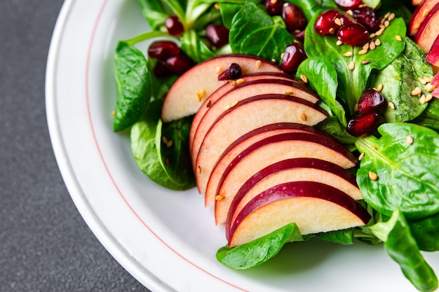 insalata di mele, lattuga mista verde, spuntino di cibo sano del chicco di melograno sullo spazio della copia del tavolo