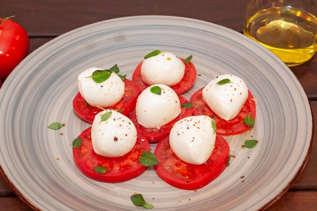 Insalata di mozzarella e pomodoro su un piatto con un bicchiere di birra