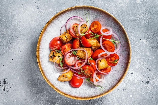 Insalata di Panzanella vegetariana fresca con pomodori, cipolla e crostini di pane Sfondo grigio Vista dall'alto