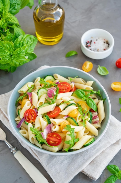 Insalata di pasta vegana sana con pomodori cetrioli cipolle rosse e rucola Copia spazio