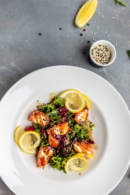 Insalata di pesce salmone, lattuga e limone. immagine verticale. vista dall'alto. posto per il testo