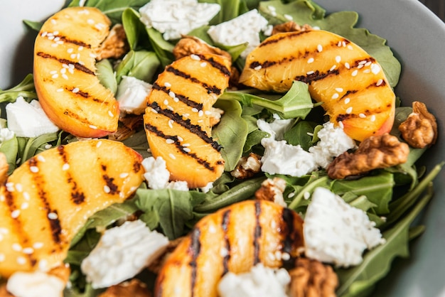 Insalata di pesche grigliate, ricotta e rucola. Cibo salutare