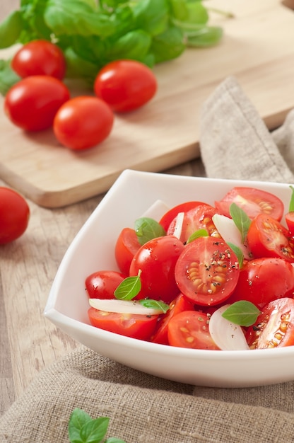 insalata di pomodori ciliegia con basilico, pepe nero e cipolla