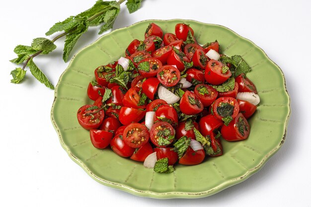 Insalata di pomodori ciliegia fatta in casa con cipolle fresche, menta, olio d'oliva e sale