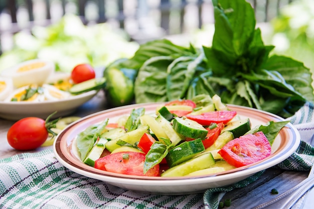 Insalata di pomodori e cetrioli con cipolle verdi e basilico.