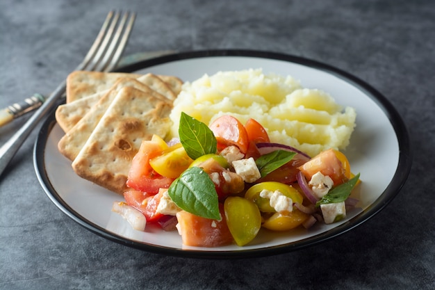 Insalata di pomodori e purè di patate in un piatto