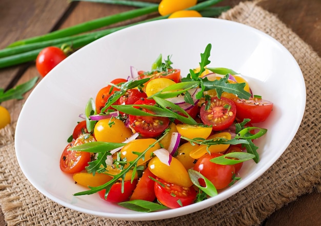 Insalata di pomodori freschi di ciliegio con cipolla e arugula