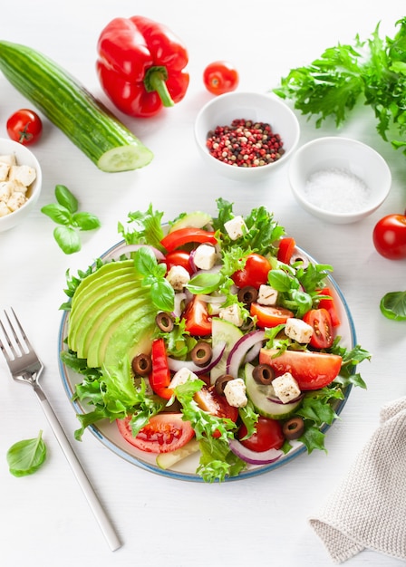 Insalata di pomodori greci avocado con formaggio feta, olive, cetriolo, cipolla, lattuga