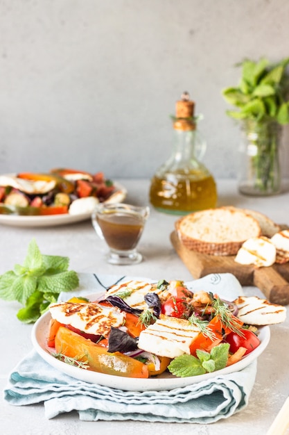 Insalata di pomodori, pepe e cipolla al forno con formaggio grigliato