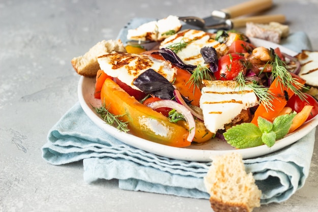 Insalata di pomodori, pepe e cipolla al forno con formaggio grigliato