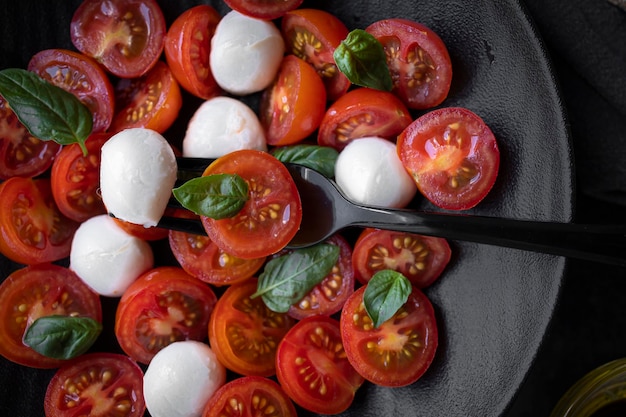 Insalata di pomodorini con mozzarella e basilico fresco. Deliziosa insalata caprese