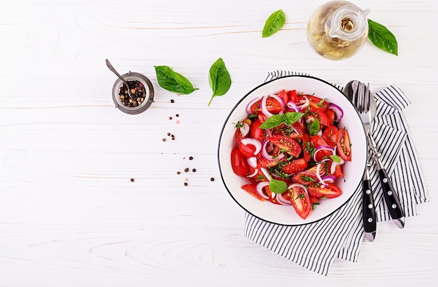 Insalata di pomodoro con basilico e cipolle rosse Cibo fatto in casa Concept pasto sano Cucina vegana Vista superiore