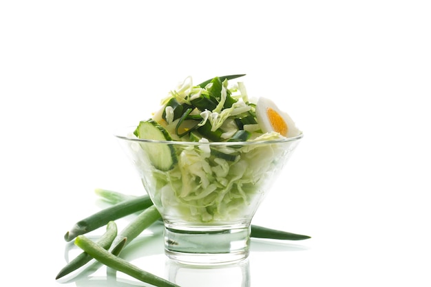 insalata di primavera con uova di cetrioli di cavolo precoce e cipolle verdi isolate su sfondo bianco