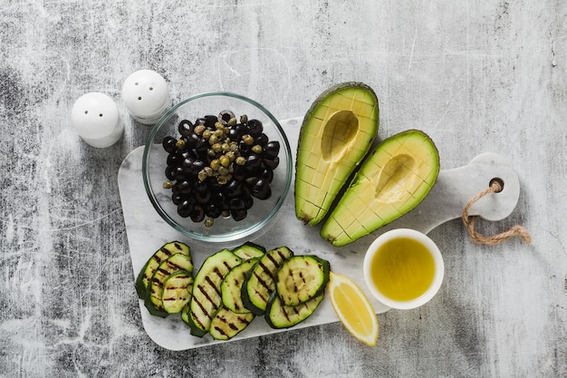 insalata di primavera di avocado maturo, zucchine grigliate, olive nere, capperi e condimenti al limone