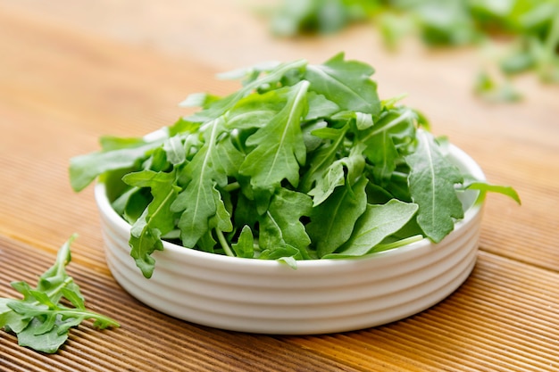 Insalata di razzo verde fresca in zolla rotonda bianca