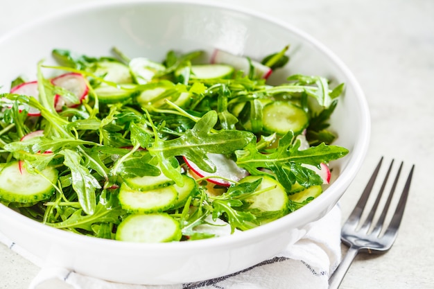 Insalata di rucola con cetriolo e ravanello. Concetto di cibo sano.