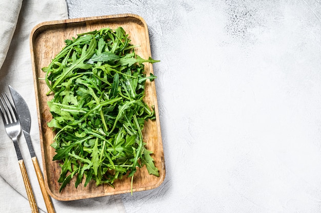 Insalata di rucola fresca in una ciotola di legno. Vista dall'alto. Copia spazio